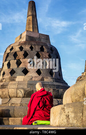 Statue de Bouddha avec un moine bouddhiste priant dans le dos, temple de Borobudur Borobudur, complexes, Yogyakarta, Java, Indonésie Banque D'Images