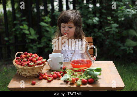 Little girl eating strawberries au chalet Banque D'Images