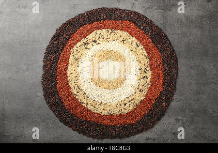 La composition avec différents types de riz sur fond gris Banque D'Images