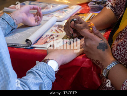 L'application de l'artiste tatouage au henné sur la main femme touristiques, Kuala Lumpur, Malaisie Banque D'Images