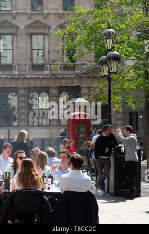 Diners savourer le déjeuner et un verre au soleil du printemps dans la ville de Londres Banque D'Images