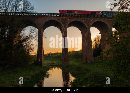 Un train de marchandises traverse Eynesford viaduc sur la rivière Darent, dans le Kent au coucher du soleil Banque D'Images