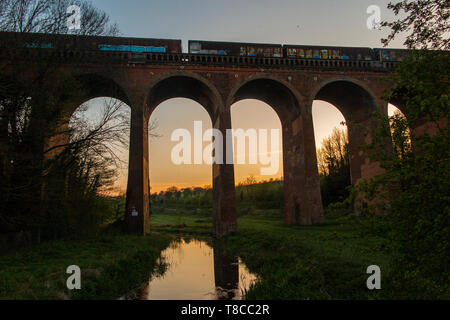 Un train de marchandises traverse Eynesford viaduc sur la rivière Darent, dans le Kent au coucher du soleil Banque D'Images