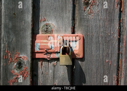 Ancien cadenas rouillé sur porte de bois de vieux hangar Banque D'Images
