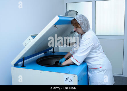 Placer les contenants avec une infirmière du sang dans une centrifugeuse. Lab de la ville (municipal) transfusion de sang. Le 5 avril 2019. Kiev, Ukraine Banque D'Images