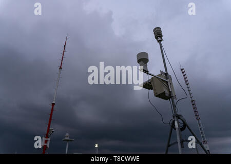 Station météorologique automatique portable à l'aéroport de Ngurah Rai sous le sombre Cumulonimbus effrayant. Cette fonction de l'outil est de mesurer les phénomènes météorologiques Banque D'Images