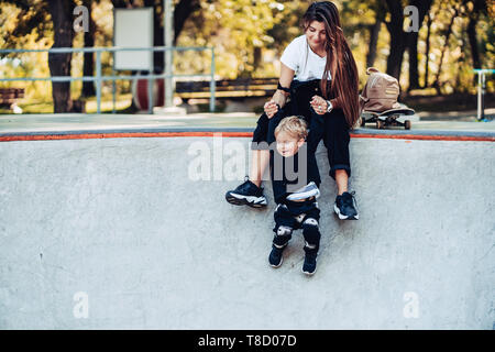 Belle jeune hipster maman tient son petit fils par la main Banque D'Images