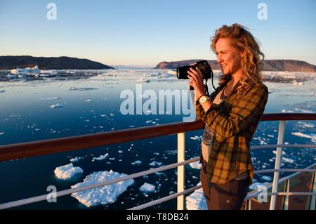 Le Groenland, côte ouest, la baie de Disko, navire de croisière Hurtigruten MS Fram se déplace entre les icebergs dans la baie de Quervain au coucher du soleil et le glacier Kangilerngata sermia dans l'arrière-plan Banque D'Images