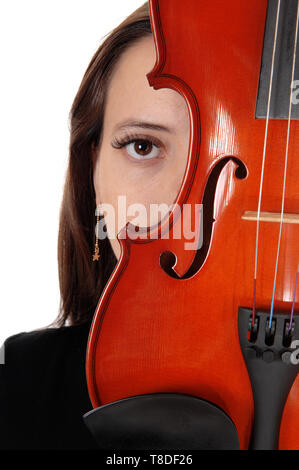 L'oeil d'une belle femme se cachant derrière un violon à la recherche dans l'appareil photo dans un close up image, isolée pour fond blanc Banque D'Images