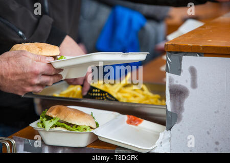 La préparation de repas à emporter avec du burger et frites à l'extérieur cuisine au festival de musique de rue à Gland, Vaud, Suisse Banque D'Images