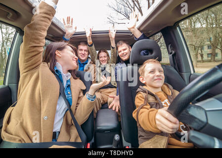 La voiture concept amusant. petit garçon voiture conduite avec des adultes personnes. manque de pilote. voyage. vue de l'intérieur Banque D'Images