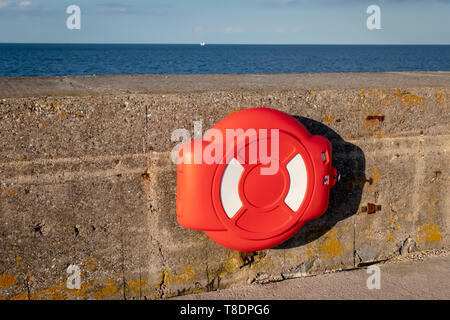 Bouée de sauvetage rouge sur le brise-lames mur du port, Brixham, Devon.Angleterre,Torbay Banque D'Images