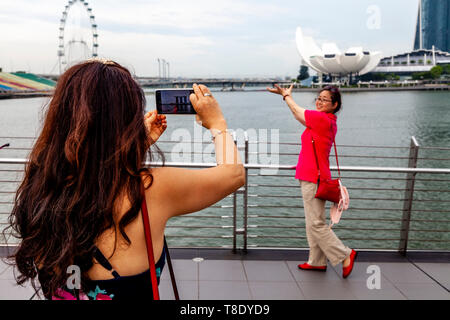 Un touriste posant pour une photo en face de l'ArtScience Museum, Marina Bay, à Singapour, en Asie du sud-est Banque D'Images