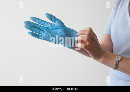 Retrait de main de femme libre de gants médicaux bleu Banque D'Images