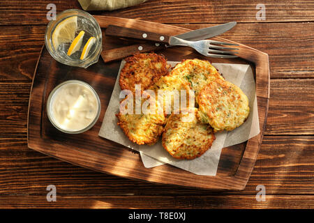 Crêpes aux courgettes et sauce sur planche de bois Banque D'Images