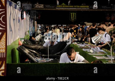 Athènes, Grèce. 12 mai, 2019. Les tatoueurs sont vu travailler sur les clients au cours de la convention internationale de tatouages.Des milliers d'artistes tatoueurs du monde entier ont pris part au cours de la 13e Convention Internationale de tatouages d'Athènes et ils ont aussi fait de tatouages des gens qui étaient intéressés. Credit : Giorgos Zachos SOPA/Images/ZUMA/Alamy Fil Live News Banque D'Images