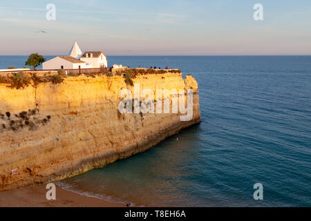 La petite chapelle Nossa Senhora da Rocha debout sur un promontoire escarpé à Armacao de Pera en Algarve, Portugal. Banque D'Images