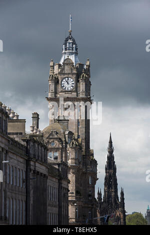 L'horloge de l'Hôtel Balmoral sur Princes Street avec le Scott Monument situé derrière et un ciel menaçant dans la distance, Édimbourg, Écosse, Royaume-Uni. Banque D'Images