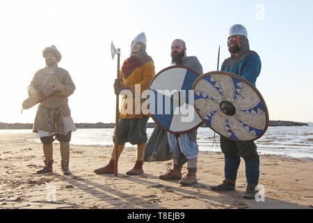 Homme reencator en costume national jouer gusli russe traditionnel ancien instrument de musique de guerriers autour de Banque D'Images