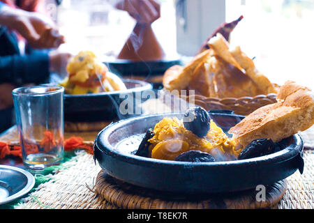 Ralentissement de la viande cuite avec les pruneaux, les amandes, les oignons et saupoudré de sésame, tajine marocain, style rustique Banque D'Images