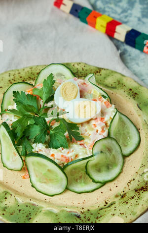 Salade de crabe et de tranches de concombre sur un beau plat fond gris Banque D'Images