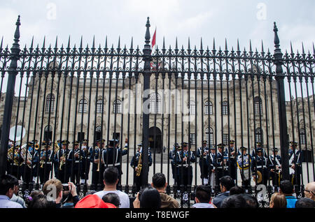 Les gens qui regardent l'évolution de la garde à l'avant du Palacio de Gobierno à Lima Banque D'Images