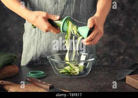 Femme faisant la courgette spaghetti, closeup Banque D'Images