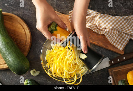 Femme faisant la courgette spaghetti, closeup Banque D'Images