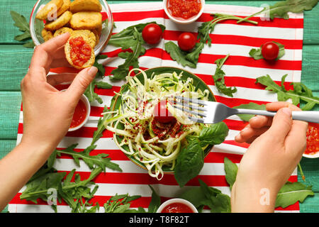 Woman eating courgette spaghetti à la sauce tomate et du pain, gros plan Banque D'Images