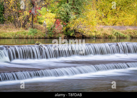 Au cours d'une cascade d'eau sur le barrage de dérivation de la rivière Powder avec couleurs d'automne au bakcground Banque D'Images