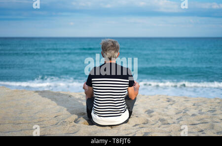 Hauts homme méditant sur la plage, vacances d'entraînement Banque D'Images