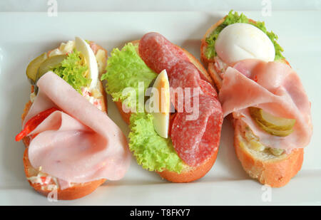 Cuisine de fête traditionnelle tchèque snack servi lors d'occasions spéciales - trois sandwichs ouverts ('chlebicky") avec divers garniture : jambon, salami fumé tranché, Banque D'Images