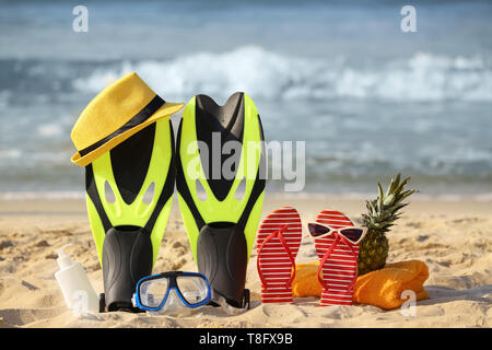 Ensemble d'articles de plage avec l'ananas sur le sable, près de la mer Banque D'Images