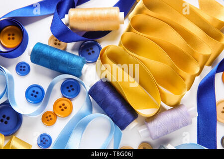 Les rubans avec différents threads et boutons sur fond blanc Banque D'Images