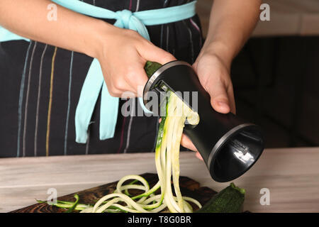 Femme faisant la courgette spaghetti, closeup Banque D'Images