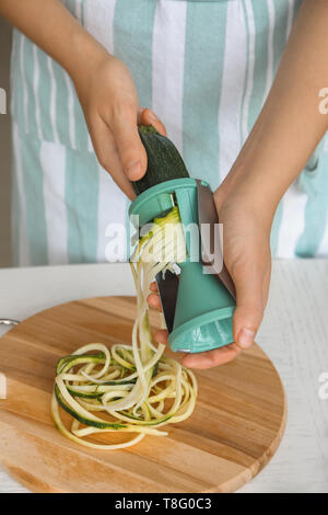 Femme faisant la courgette spaghetti, closeup Banque D'Images