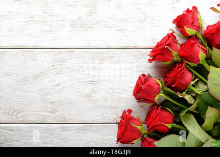 Belles roses rouges sur fond de bois blanc Banque D'Images