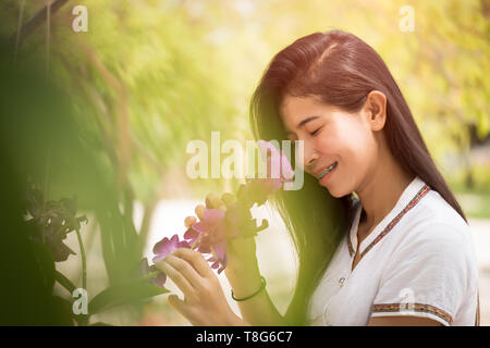 Happy young asian woman holding orchid avec un sourire heureux dans la région de Neuhausen. Banque D'Images