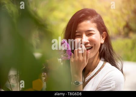 Happy young asian woman holding orchid avec un sourire heureux dans la région de Neuhausen. Banque D'Images