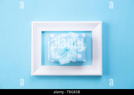 Heureux pères jours concept. Vue de dessus du cadre photo et boîte-cadeau avec happy father's day texte sur fond bleu pastel. Mise à plat. Banque D'Images