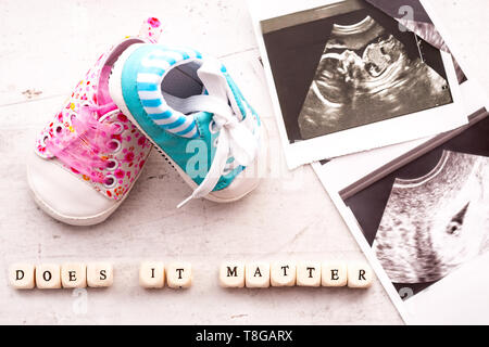 Chaussons pour bébé bleu et rose avec une photo de l'échographie de 20 semaines et 4 semaines sur un fond clair. Est-il important d'inscription Banque D'Images