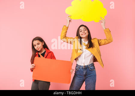 Photo de cheerful in casual tenant deux copyspace isolé des plaques sur fond rouge Banque D'Images