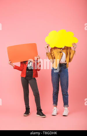 Photo de deux jeunes filles en tenue décontractée copyspace pensé sur fond rouge isolé bannières Banque D'Images