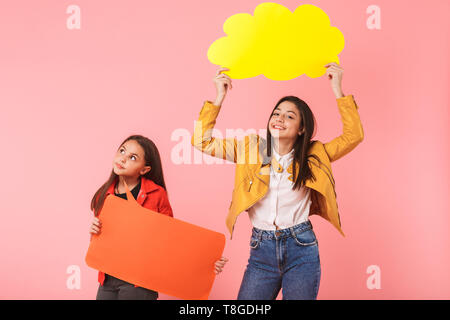 Photo de teen girls in casual tenant deux copyspace isolé des plaques sur fond rouge Banque D'Images