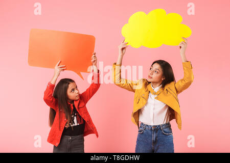 Photo de jeunes filles en tenue décontractée deux copyspace isolé des plaques sur fond rouge Banque D'Images