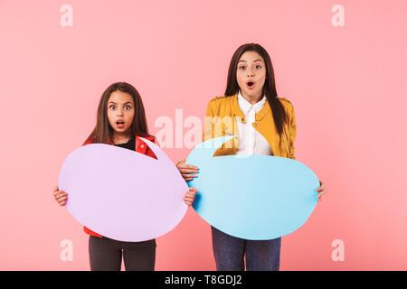 Photo de belles filles en tenue décontractée copyspace isolé deux bulles sur fond rouge Banque D'Images