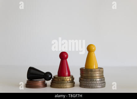 Les piles de pièces avec la figure jaune rouge noir Banque D'Images