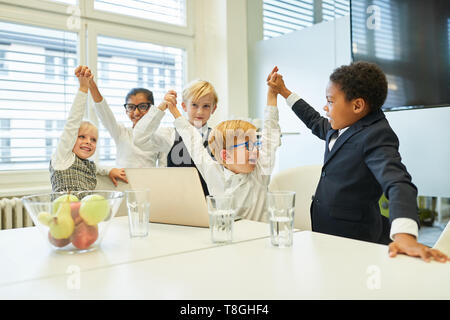 Groupe multiculturel d'enfants comme une entreprise réussie d'encouragement de l'équipe au bureau Banque D'Images