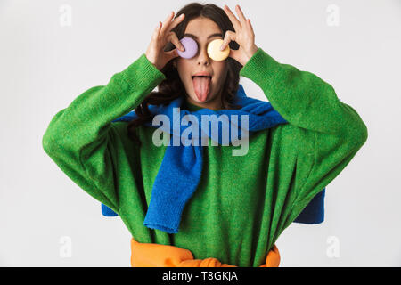 Portrait de jeune femme 30s dans des vêtements colorés holding macaron cookies tout en isolés sur fond blanc Banque D'Images