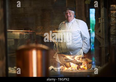 La France, l'Aveyron, Monteils, La Ferme de Carles, portrait de Jacques Carles, la cuisson au feu de bois dans les chaudrons de cuivre, le cou de canard fourré au foie gras Banque D'Images